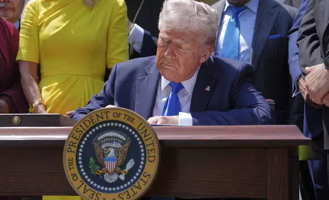 President Donald Trump signs an executive order establishing the Religious Liberty Commission, during a National Day of Prayer event in the Rose Garden of the White House, Thursday, May 1, 2025, in Washington. (AP Photo/Evan Vucci)