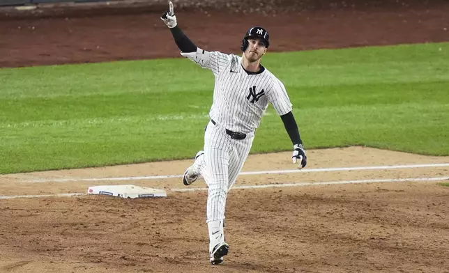 New York Yankees' Cody Bellinger gestures as he runs the bases after hitting a grand slam during the eighth inning of a baseball game against the New York Mets Sunday, May 18, 2025, in New York. (AP Photo/Frank Franklin II)
