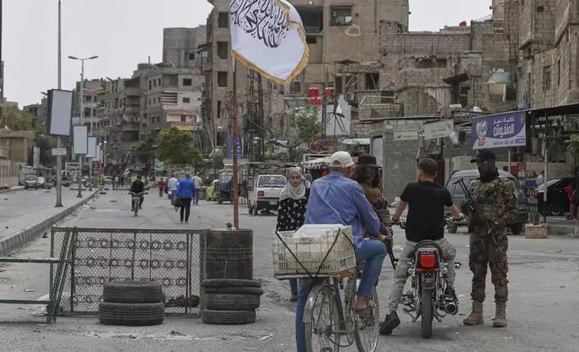 Syrian government security forces stand guard on their checkpoint, at one of Jaramana suburb entrances, after clashes in the area between members of the minority Druze sect and pro-government fighters, in the southern suburb of Jaramana, Damascus, Syria, Wednesday, April 30, 2025. (AP Photo/Omar Sanadiki)