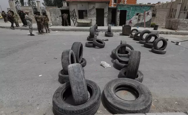 Syrian government security forces stand guard on their checkpoint at one of Jaramana suburb entrances, after clashes in the area between members of the minority Druze sect and pro-government fighters, in the southern suburb of Jaramana, Damascus, Syria, Wednesday, April 30, 2025. (AP Photo/Omar Sanadiki)