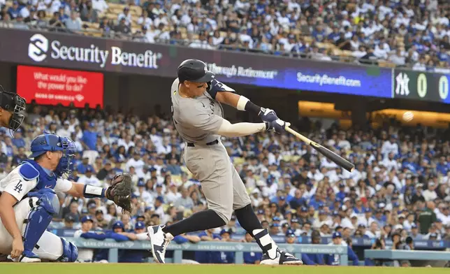 New York Yankees' Aaron Judge ,right, hits a solo home run as Los Angeles Dodgers catcher Will Smith watches during the first inning of a baseball game Friday, May 30, 2025, in Los Angeles. (AP Photo/Mark J. Terrill)