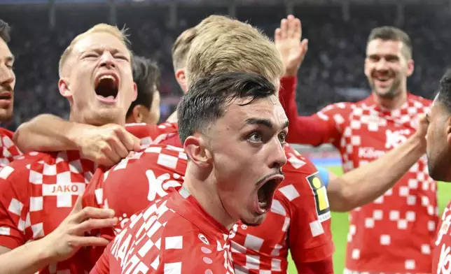 Mainz's Paul Nebel, foreground, celebrates the goal by Jonathan Burkhardt, during the German Bundesliga soccer match between FSV Mainz 05 and Eintracht Frankfurt, at Mewa Arena, in Mainz, Germany, Sunday, May 4, 2025. (Torsten Silz/dpa via AP)