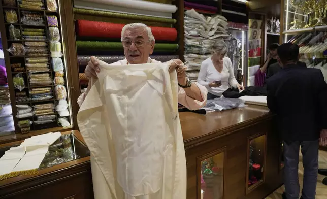 Italian tailor Raniero Mancinelli, who on his own initiative is making outfits for a possible future Pope, shows a pontiff's unfinished garment as he is interviewed by the Associated Press inside his shop in Rome, Wednesday, April 30, 2025. (AP Photo/Gregorio Borgia)