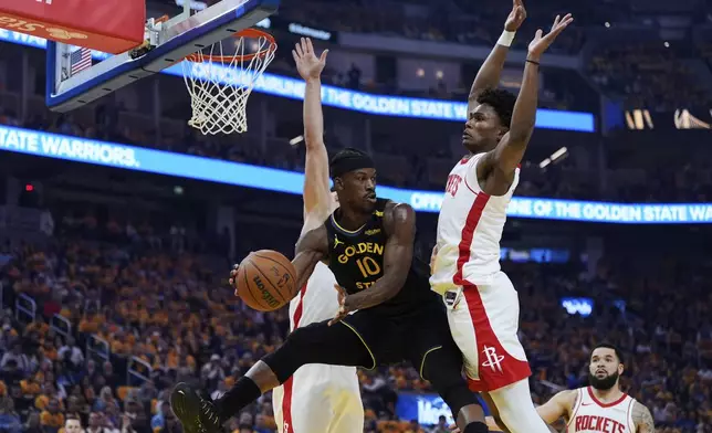 Golden State Warriors forward Jimmy Butler III (10) passes the ball between Houston Rockets center Alperen Sengun, left, and forward Amen Thompson during the first half of Game 6 of an NBA basketball first-round playoff series Friday, May 2, 2025, in San Francisco. (AP Photo/Godofredo A. Vásquez)