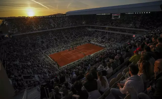 The sun sets during the second round match of the French Tennis Open between Denmark's Holger Rune and Emilio Nava of the United States at the Roland-Garros stadium in Paris, Wednesday, May 28, 2025. (AP Photo/Aurelien Morissard)