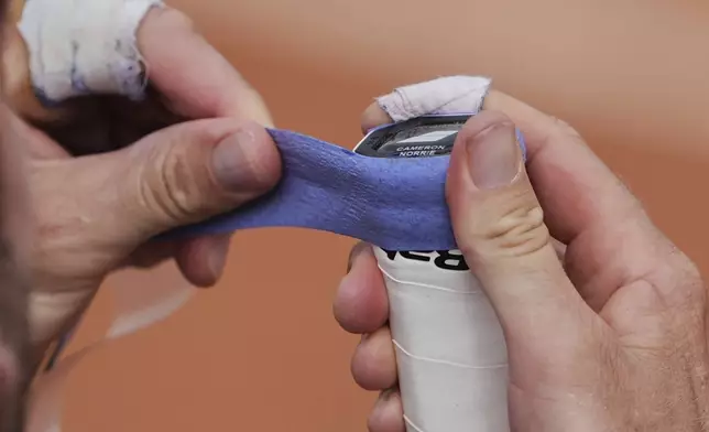 Britain's Cameron Norrie changes his racket's overgrip as he plays Argentina's Federico Gomez during their second round match of the French Tennis Open, at the Roland-Garros stadium, in Paris, Thursday, May 29, 2025. (AP Photo/Lindsey Wasson)