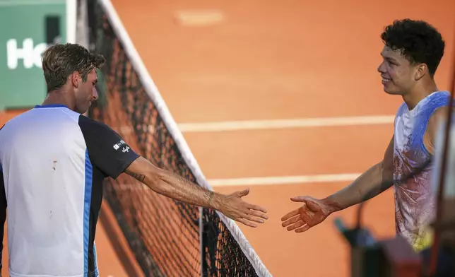 Italy's Matteo Gigante, left, and Ben Shelton of the U.S. congratulate each other during their third round match of the French Tennis Open, at the Roland-Garros stadium, in Paris, Friday, May 30, 2025. (AP Photo/Thibault Camus)