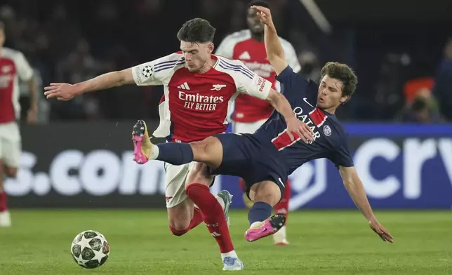 PSG's Joao Neves, right, challenges Arsenal's Declan Rice during the Champions League semifinal, second leg soccer match between Paris Saint-Germain and Arsenal at the Parc des Princes in Paris, Wednesday, May 7, 2025. (AP Photo/Thibault Camus)