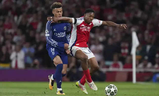 Arsenal's Jurrien Timber, right, fights for the ball with PSG's Desire Doue during the Champions League semifinal first leg soccer match between Arsenal and Paris Saint-Germain at Emirates Stadium in London, England, Tuesday, April 29, 2025. (AP Photo/Kirsty Wigglesworth)