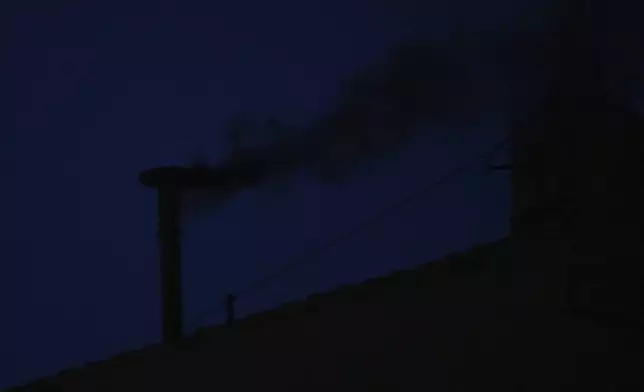 Black smoke billows from the chimney of the Sistine Chapel during the conclave to elect a new pope, at the Vatican, Wednesday, May 7, 2025. (AP Photo/Andrew Medichini)