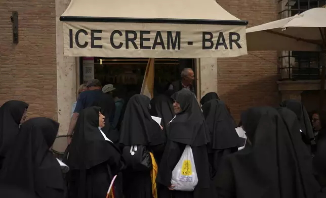 Nuns enter an ice cream coffee bar near the Vatican, in Rome, on Wednesday, May 7, 2025, on the day cardinals sequester themselves at the Vatican for the start of a conclave to elect the 267th Roman pontiff, a successor to Pope Francis. (AP Photo/Francisco Seco)