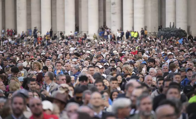 People gather in St Peter's Square as they wait to see the smoke billow from the chimney of the Sistine Chapel in St Peter's Square during the cardinals' conclave to elect a new pope, at the Vatican, Wednesday, May 7, 2025. (AP Photo/Andrew Medichini)