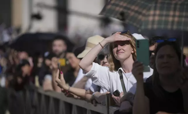 People watch on a giant screen as the cardinals take their oath in the Sistine Chapel during the cardinals' conclave to elect a new pope, at the Vatican, Wednesday, May 7, 2025. (AP Photo/Alessandra Tarantino)