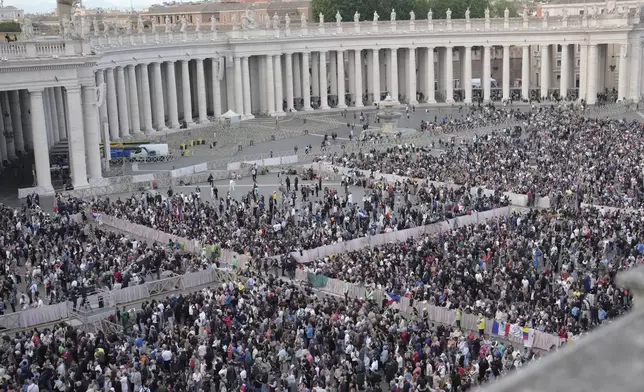People gather in St Peter's Square as they wait to see the smoke billow from the chimney of the Sistine Chapel in St Peter's Square during the cardinals' conclave to elect a new pope, at the Vatican, Wednesday, May 7, 2025. (AP Photo/Markus Schreiber)