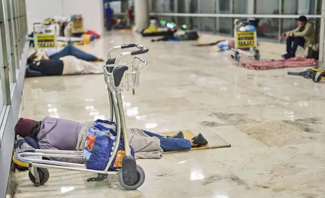 People sleep on the floor of Terminal 4 at Adolfo Suarez-Madrid Barajas Airport in Madrid, Spain, Thursday, May 15, 2025. (AP Photo/Manu Fernandez)