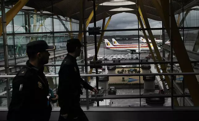 FILE - Iberia jets are seen in a parking zone as police walk through the airport during a Iberia airline workers strike at Barajas international airport in Madrid, Spain, Tuesday, March 5, 2013. (AP Photo/Andres Kudacki, File)