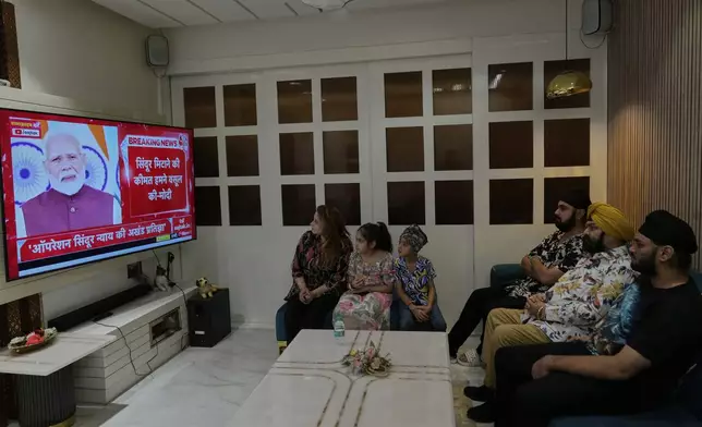 Family members watch the live telecast of Indian Prime Minister Narendra Modi's speech on a television at their residence in Hyderabad, India, Monday, May 12, 2025. (AP Photo/Mahesh Kumar A.)