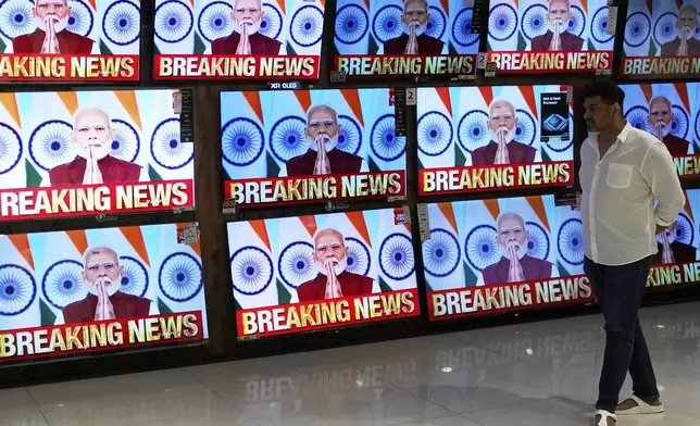 A man watches the live telecast of Indian Prime Minister Narendra Modi's speech on television screens at a shopping mall after 'Operation Sindoor' in Mumbai, India, Monday, May 12, 2025. (AP Photo/Rajanish Kakade)