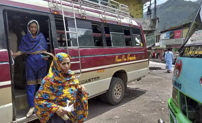 Local residents depart a passenger bus upon their arrival at a bus terminal, day after the ceasefire between Indian and Pakistan was announced, in Chakothi, near Line of Control, some 61 kilometres (38 miles) from Muzaffarabad, the capital of Pakistan controlled Kashmir, Sunday, May 11, 2025. (AP Photo/Roshan Mughal)