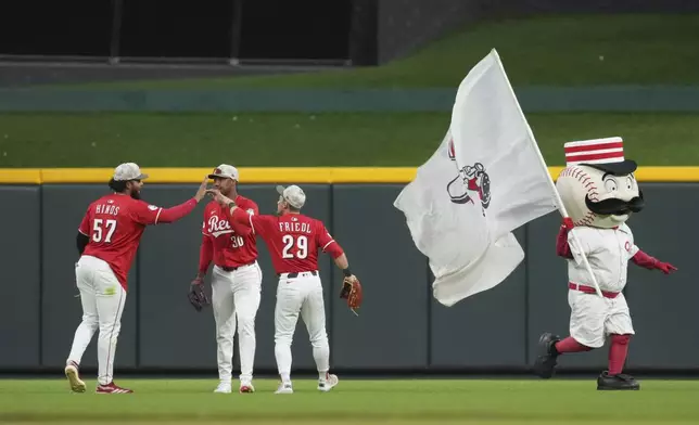 Cincinnati Reds' Rece Hinds (57) celebrates with teammates Will Benson (30) and TJ Friedl (29) following a baseball game against the Cleveland Guardians, Saturday, May 17, 2025, in Cincinnati. (AP Photo/Jeff Dean)