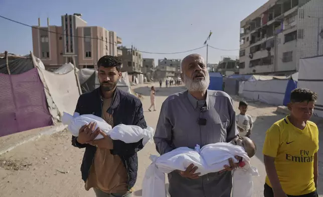 Abdel Rahman Sinwar, left, carries the body of his infant son, Yahia Sinwar, while the child's grandfather carries the body of his one-year-old grandson, Seif Sinwar, both killed in an Israeli army strike in Khan Younis, Gaza Strip, on Saturday, May 3, 2025. (AP Photo/Abdel Kareem Hana)