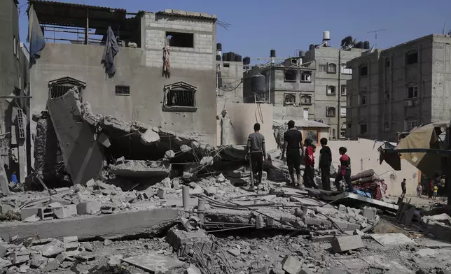Palestinians look at a house targeted by an Israeli army strike in Khan Younis, Gaza Strip, Saturday, May 3, 2025. (AP Photo/Abdel Kareem Hana)