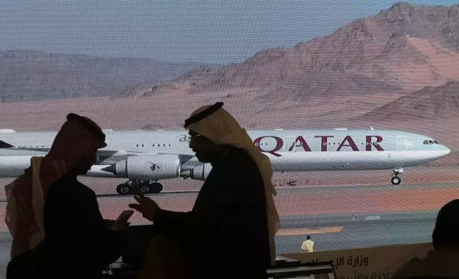 FILE - Journalists chat as video of a plane is shown on a screen while landing at at Al Ula airport in Saudi Arabia, Jan. 5, 2021. (AP Photo/Amr Nabil, file)