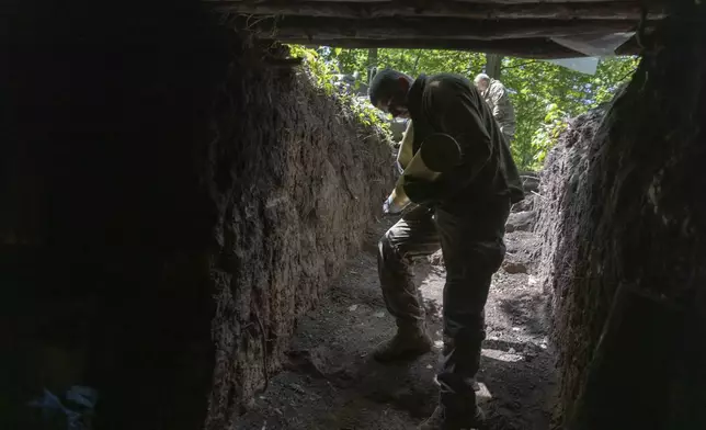 A Ukrainian serviceman of the 127th Territorial Defence Brigade carries a shell to fire KS-19 100mm gun towards Russian positions near Kharkiv, Ukraine, Friday, May 16, 2025. (AP Photo/Yevhen Titov)