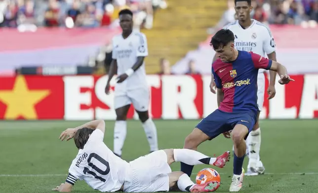 Real Madrid's Luka Modric tackles Barcelona's Pedri during the La Liga soccer match between Barcelona and Real Madrid in Barcelona, Spain, Sunday, May 11, 2025. AP Photo/Joan Monfort)