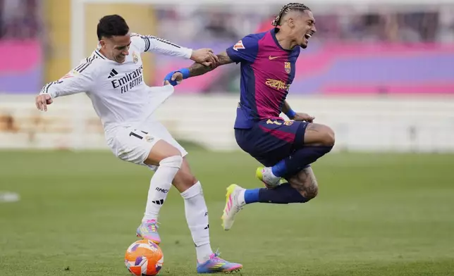 Barcelona's Raphinha, right, and Real Madrid's Lucas Vazquez fight for the ball during the Spanish La Liga soccer match between Barcelona and Real Madrid at the Lluis Companys Olympic Stadium in Barcelona, Spain, Sunday, May 11, 2025. (AP Photo/Jose Breton)
