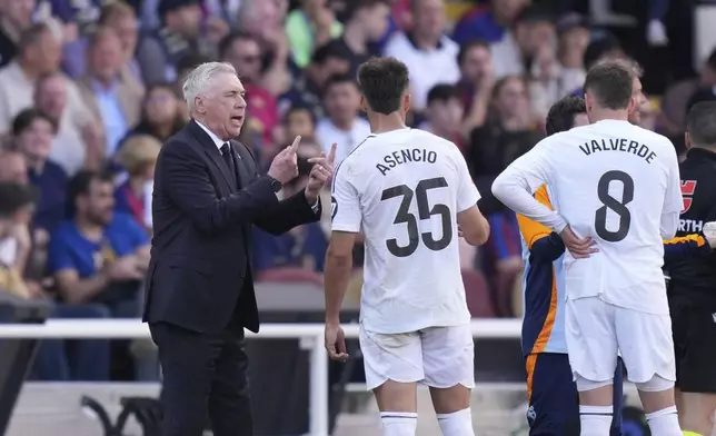 Real Madrid's head coach Carlo Ancelotti, left, gives instructions during the Spanish La Liga soccer match between Barcelona and Real Madrid at the Lluis Companys Olympic Stadium in Barcelona, Spain, Sunday, May 11, 2025. (AP Photo/Jose Breton)