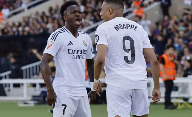 Real Madrid's Vinicius Junior, left, and Kylian Mbappe celebrate after a goal during the La Liga soccer match between Barcelona and Real Madrid in Barcelona, Spain, Sunday, May 11, 2025. AP Photo/Joan Monfort)