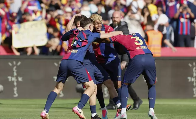 Barcelona players celebrate after the La Liga soccer match between Barcelona and Real Madrid in Barcelona, Spain, Sunday, May 11, 2025. AP Photo/Joan Monfort)