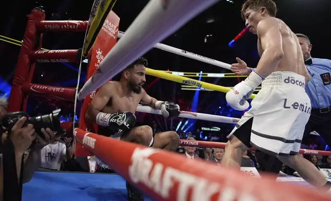 Naoya Inoue, right, knocks down Ramon Cardenas in a junior featherweight title boxing match Sunday, May 4, 2025, in Las Vegas. (AP Photo/John Locher)