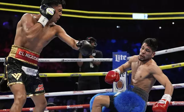 Emiliano Fernando Vargas knocks down Juan Leon in a junior welterweight boxing match Sunday, May 4, 2025, in Las Vegas. (AP Photo/John Locher)