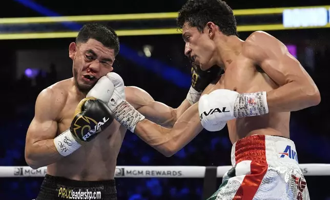 Rafael Espinoza hits Edward Vazquez in a featherweight title boxing match Sunday, May 4, 2025, in Las Vegas. (AP Photo/John Locher)