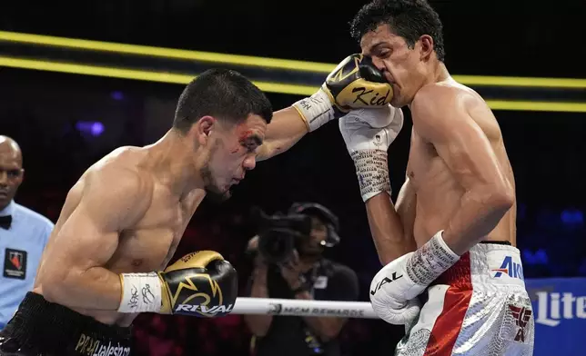 Edward Vazquez hits Rafael Espinoza in a featherweight title boxing match Sunday, May 4, 2025, in Las Vegas. (AP Photo/John Locher)