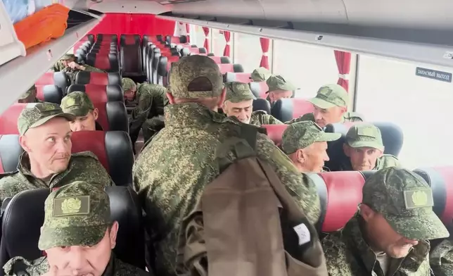 In this photo taken from a video released by Russian Defense Ministry press service, Russian servicemen ride a bus after returning from captivity after an exchange between Russia and Ukraine, at an undisclosed location in Belarus, Saturday, May 24, 2025. (Russian Defense Ministry Press Service via AP)