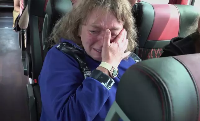 In this photo taken from a video released by Russian Defense Ministry press service, a woman who was captured by Ukrainian Army in Kursk region of Russia, cries while riding a bus after returning from captivity after an exchange between Russia and Ukraine, at an undisclosed location in Belarus, Friday, May 23, 2025. (Russian Defense Ministry Press Service via AP)