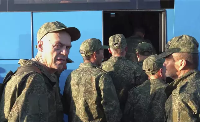 In this photo taken from video released by Russian Defense Ministry Press Service on Saturday, May 24, 2025, Russian servicemen board a bus upon arrival to Chkalovsky airport, outside Moscow, Russia, after returning from captivity by a POWs exchange between Russia and Ukraine. (Russian Defense Ministry Press Service photo via AP)