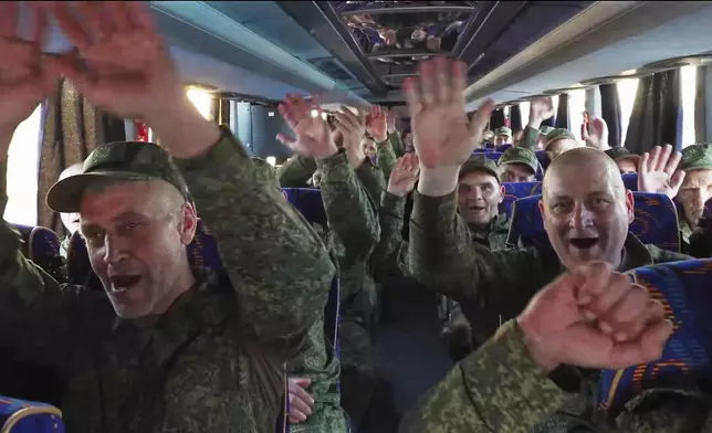 In this photo taken from video released by Russian Defense Ministry Press Service on Saturday, May 24, 2025, Russian servicemen react in a bus upon arrival to Chkalovsky airport, outside Moscow, Russia, after returning from captivity by a POWs exchange between Russia and Ukraine. (Russian Defense Ministry Press Service photo via AP)