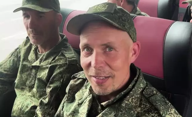 In this photo, taken from a video released by Russian Defense Ministry press service, Russian servicemen sit in a bus after returning from captivity after an exchange between Russia and Ukraine, at an undisclosed location in Belarus, Saturday, May 24, 2025. (Russian Defense Ministry Press Service via AP)