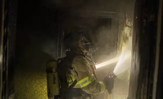 Firefighters extinguish a fire in a residential building damaged after a Russian attack in Kyiv, Ukraine, Saturday, May 24, 2025 (AP Photo/Alex Babenko)