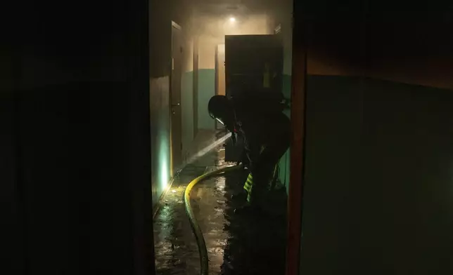 Firefighters works in residential building damaged after a Russian attack in Kyiv, Ukraine, Saturday, May 24, 2025 (AP Photo/Alex Babenko)