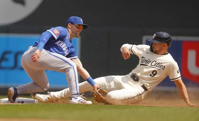 Kansas City Royals second baseman Michael Massey, left, tags out Minnesota Twins' Trevor Larnach, right, on a stolen base-attempt in the eighth inning of a baseball game Sunday, May 25, 2025, in Minneapolis. (AP Photo/Bruce Kluckhohn)