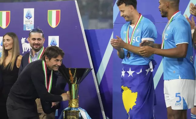 Napoli's head coach Antonio Conte celebrates with the trophy after winning the Italian league soccer title at the end of the Serie A soccer match between Napoli and Cagliari at the Diego Maradona stadium in Naples, Italy, Saturday, May 24, 2025. (AP Photo/Gregorio Borgia)