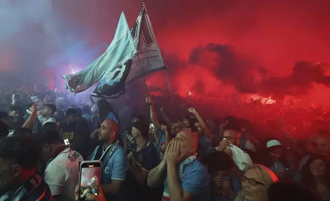 Napoli's fans celebrate as they watch the decisive match for the Italian league soccer title between Napoli and Cagliari on a giant screen set in Piazza del Plebiscito, in Naples, Italy, Friday, May 23, 2025. (AP Photo/Salvatore Laporta)