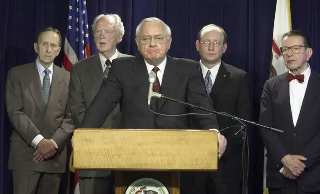 FILE - Gov. George Ryan listens to a reporter's question after a report by a state panel on capital punishment, formed two years earlier by Ryan, was released in Chicago during a news conference Monday, April 15, 2002. Looking on, from left, are commission members Thomas Sullivan, Judge Frank McGarr, Matt Bettenhausen and former U.S. Sen. Paul Simon. (AP Photo/M. SpencerGreen, File)