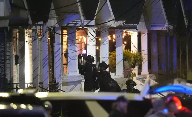 Louisiana state police enter a house on North Galvez street as they pursue a fugitive that escaped from a New Orleans jail, Tuesday, May 20, 2025, in New Orleans. (AP Photo/Gerald Herbert)