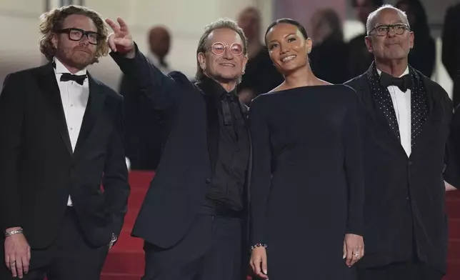 Erik Messerschmid, from left, Bono, Kelly McNamara, and Jon Kamen pose for photographers upon arrival at the premiere of the film 'Bono: Stories of Surrender' at the 78th international film festival, Cannes, southern France, Friday, May 16, 2025. (AP Photo/Natacha Pisarenko)